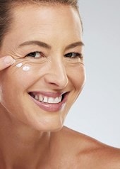 Frau trägt Anti-Aging-Serum auf fettige Haut auf, Nahaufnahme des Gesichts.