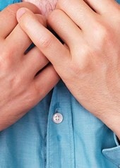 Un homme à la chemise trempée de sueur au niveau du torse tient son col à deux mains.