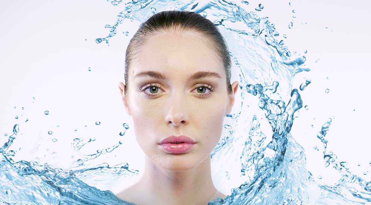 Gesicht einer Frau mit Wasserbewegung, steht für Feuchtigkeit und Pflege bei trockener Haut