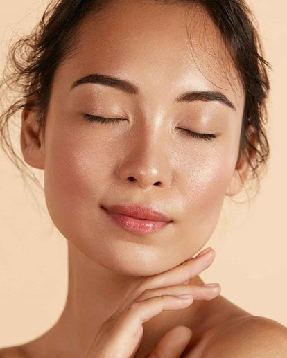 Une Femme apaisée à la peau lumineuse, symbole d’hydratation et de bien-être naturel
