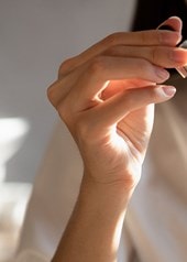 Eine Frau mit Gesichtsserum in der Hand