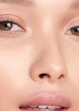 Frau mit braunen Augen hält ihre Hände an die Schläfen