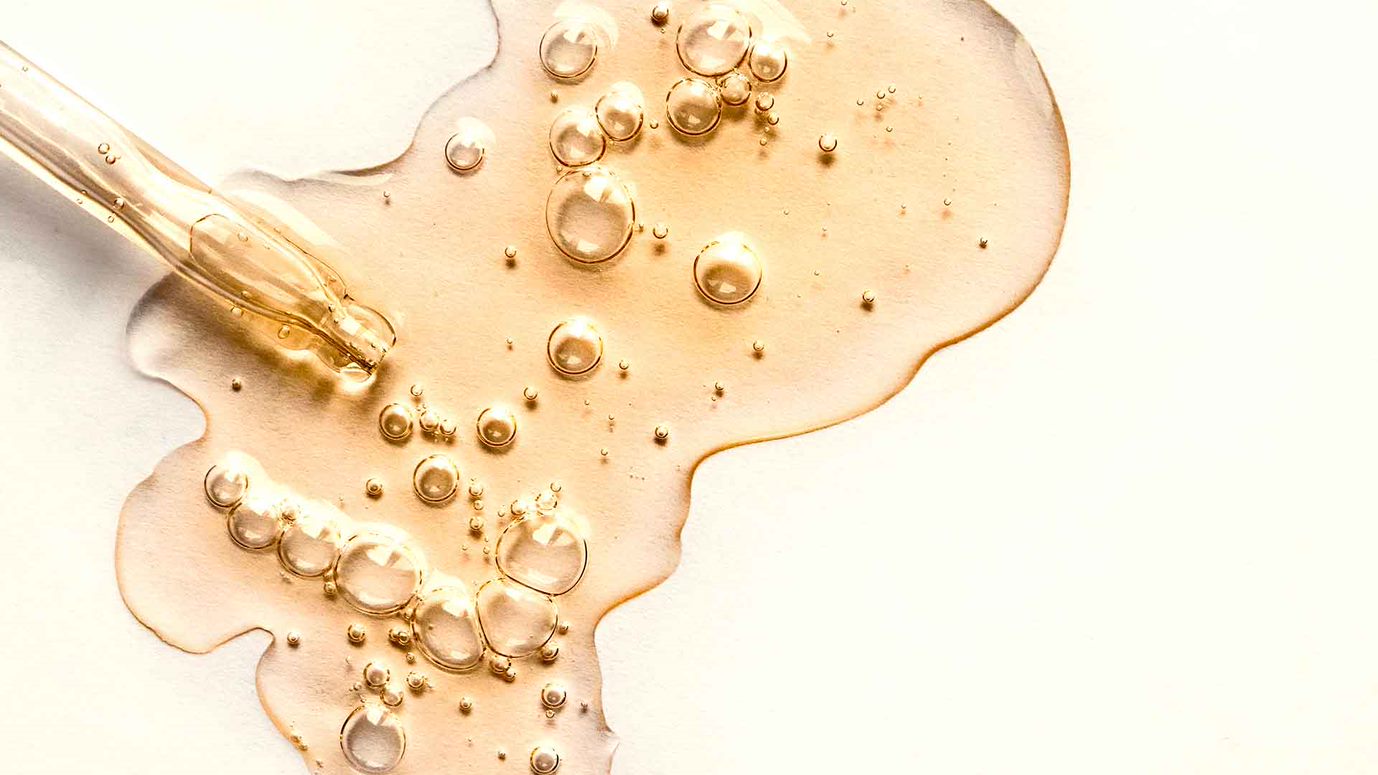 Aprikosenkernöl aus einer Pipette auf hellem Hintergrund