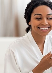 Junge Frau benutzt Serum im Gesicht