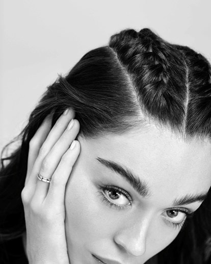 Schwarz-weiss-Foto von einer Frau mit seitlicher Flechtfrisur. Ihre Hand mit einem Ring ist im Vordergrund zu sehen.