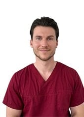 Dr. Rouben Czwikla im dunkelroten Arztkittel