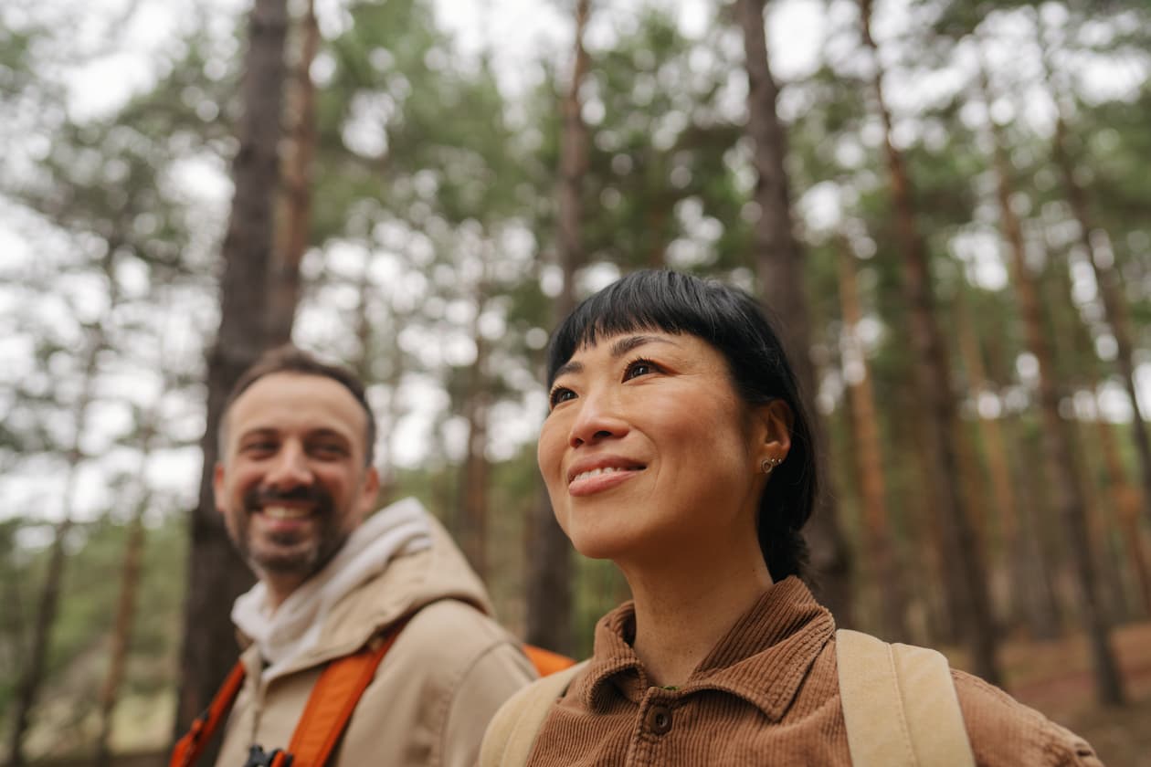 Zwei Menschen mit Rucksäcken bei einer Wanderung im Wald
