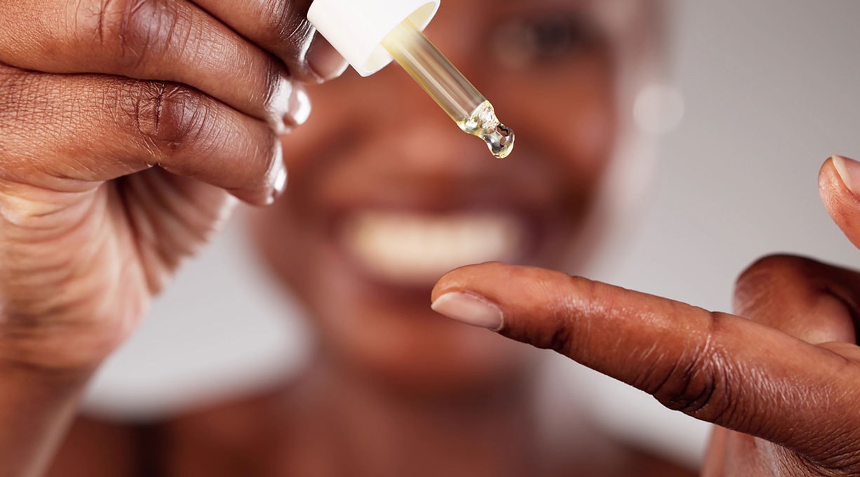 Nahaufnahme einer Hand, die eine Serum-Pipette hält.