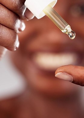 Nahaufnahme einer Hand, die eine Serum-Pipette hält.