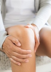 Person hält ihr Knie fest