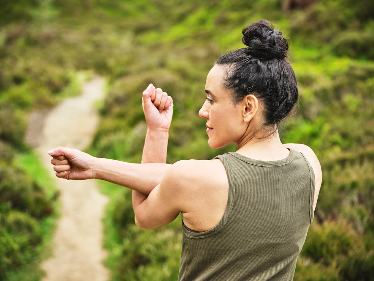 Frau dehnt ihre Arme beim Training im Freien zur Unterstützung ihrer Gelenke