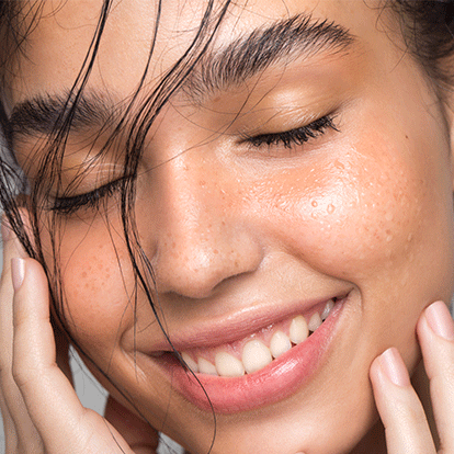 Ein paar Tropfen Squalan auf einem apricotfarbenen Untergrund