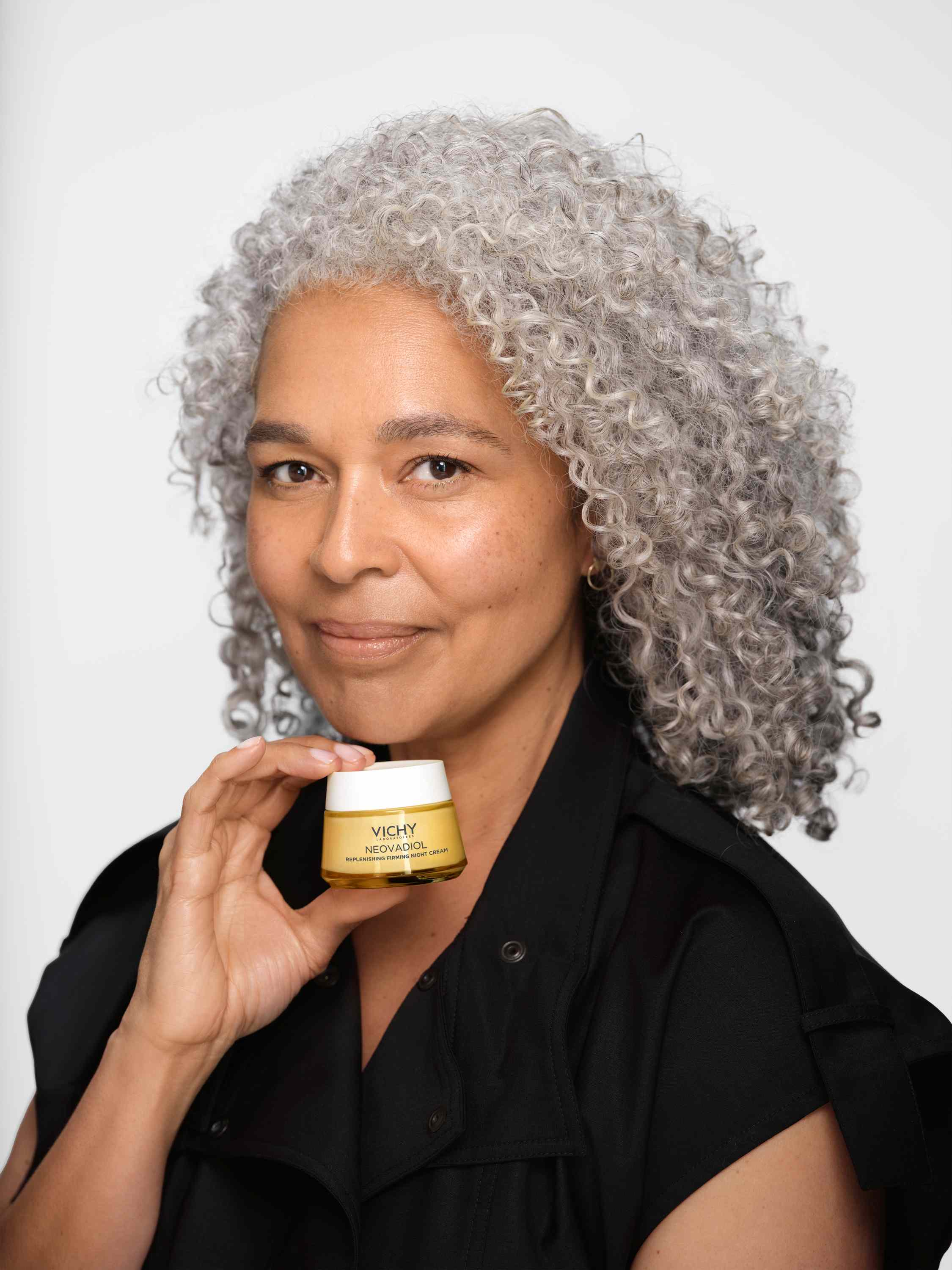 Frau mit grauen Locken hält die Vichy NEOVADIOL Nachtcreme in der Hand