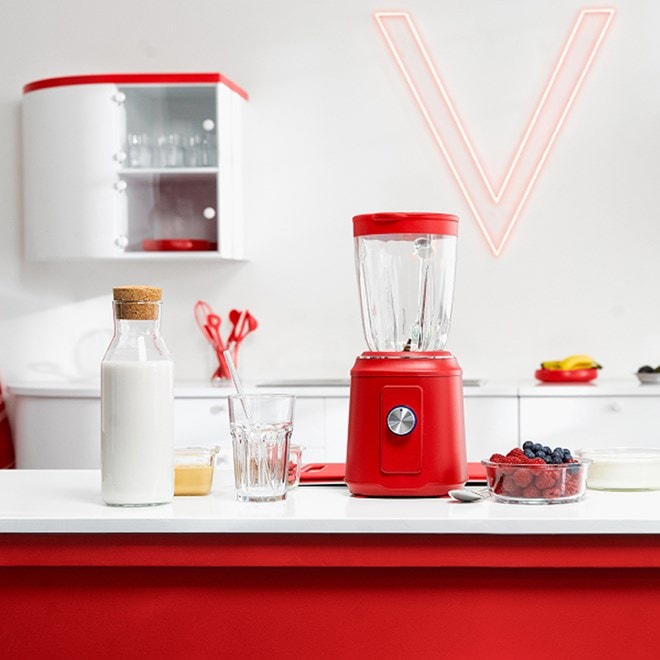 Nahaufnahme einer roten Küche mit einem roten Smoothiemaker und einer weißen Milchflasche daneben