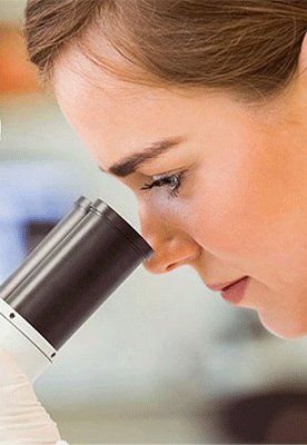 Wissenschaftlerin schaut durch ein Mikroskop