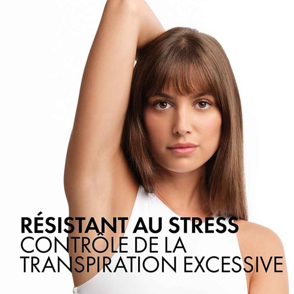 Une jeune femme lève le bras et montre ses aisselles lisses, ainsi que les avantages du déodorant roll-on VICHY stress resist 72h pour réguler la transpiration excessive.