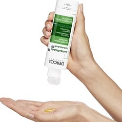 Une petite quantité de DERCOS Shampoing antipelliculaire est versée dans la main gauche.