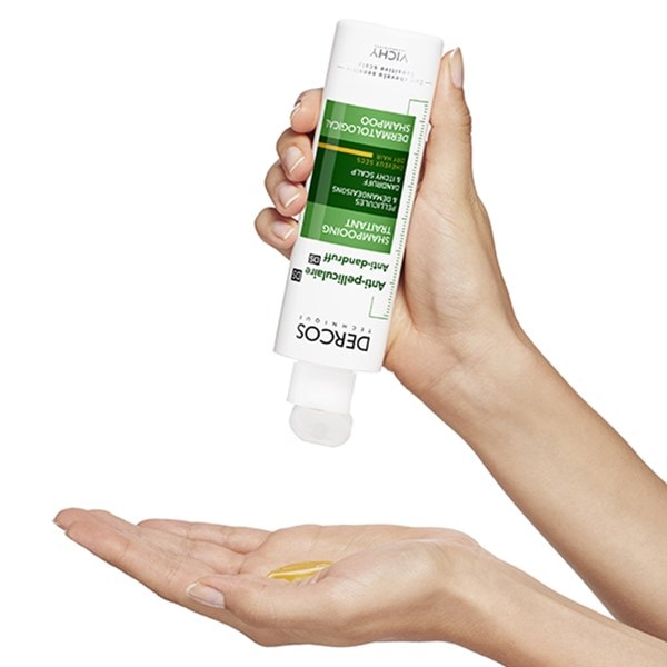 Eine Hand gibt vor dem Auftragen auf die Kopfhaut eine Portion des DERCOS Anti-Schuppen Shampoos für trockenes Haar auf die Hand