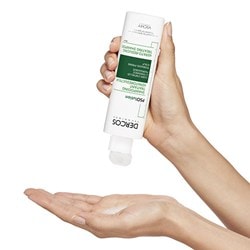 Une petite quantité du shampooing DERCOS Technique Psolution est versée dans la main gauche.