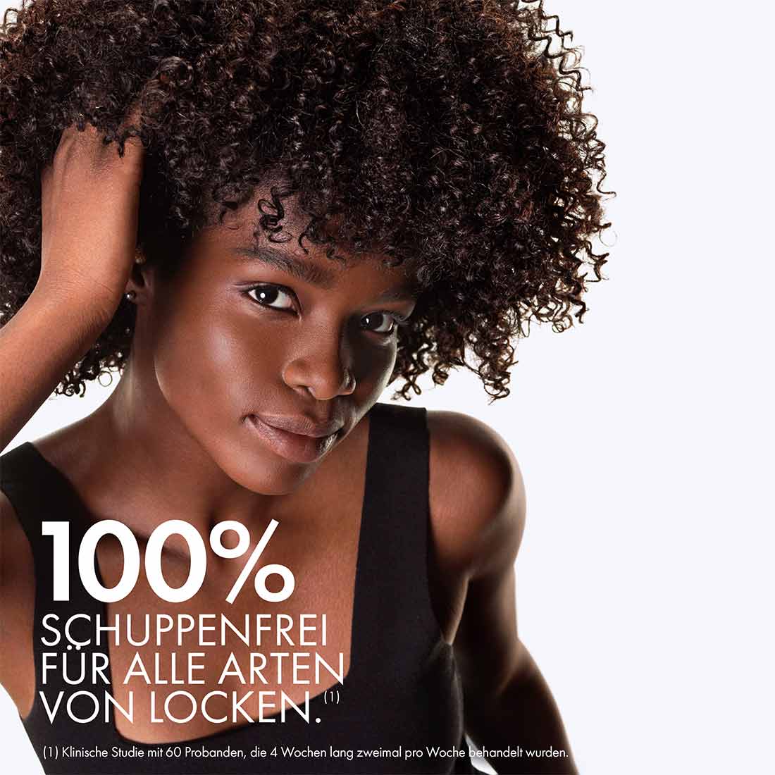 Dunkelhäutige Frau mit Afro-Haaren mittlerer Länge. Schuppenfrei und gesunde Kopfhaut nach vier Wochen Nutzung von Vichy Dercos Shampoo.