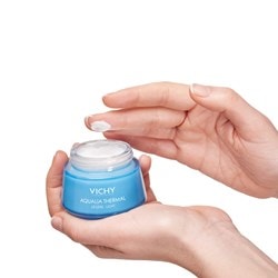 Deux mains tenant le pot de crème hydratante AQUALIA THERMAL