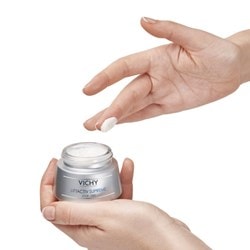 Un doigt prélève de la crème dans un pot de crème LIFTACTIV SUPREME de Vichy.