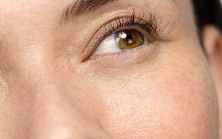 Ein braunes Auge mit Wimpern und einem Stück der Augenbraue