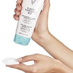 Hand trägt die PURETÉ THERMALE 3in1 Gesichtsreinigung von Vichy auf einen Pad auf