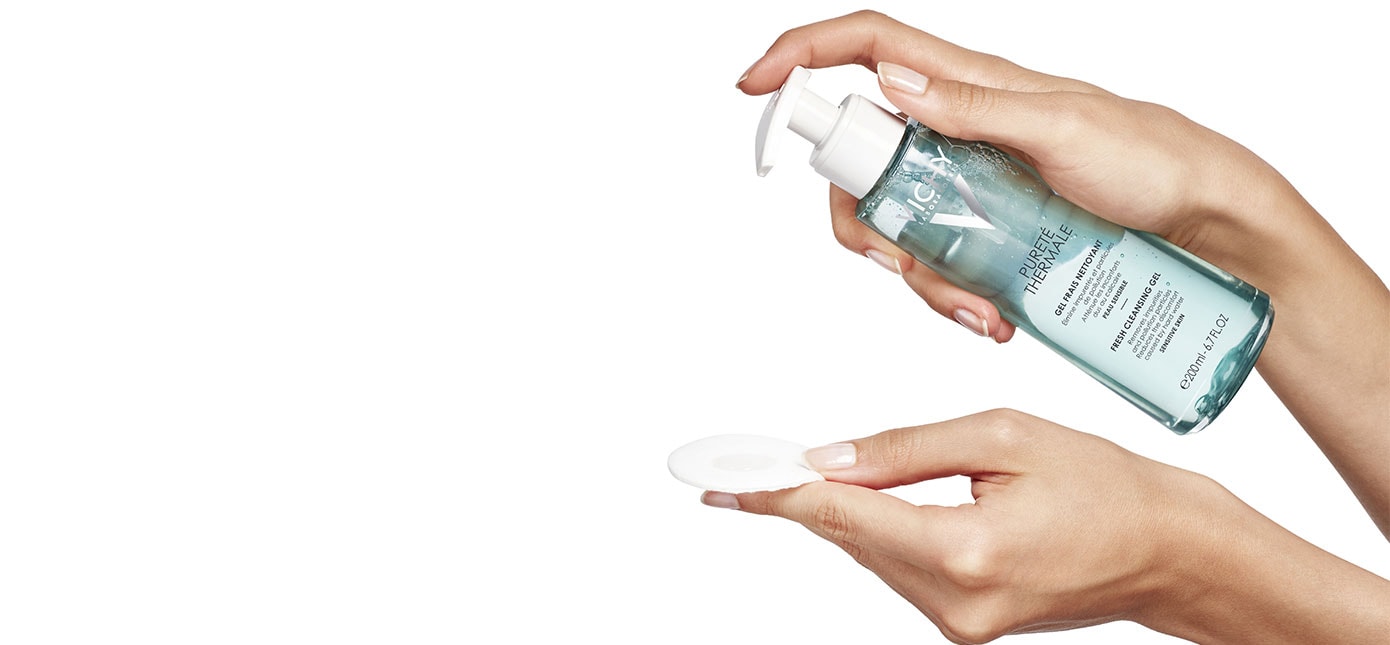 Eine Hand verteilt das PURETÉ THERMALE Reinigungsgel von Vichy auf einem weissen Pad