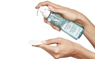 Eine Hand verteilt das PURETÉ THERMALE Reinigungsgel von Vichy auf einem weissen Pad