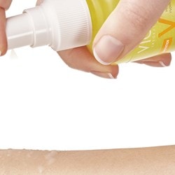 Le pulvérisateur du spray solaire Vichy est activé et appliqué sur la peau.